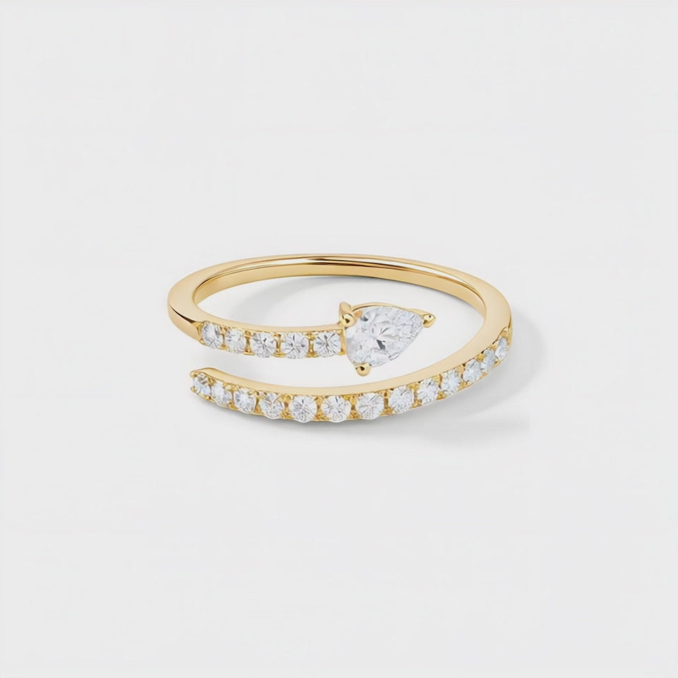 Perfect Pear ring set with a single pear and brilliant cut diamonds. Mounted in 18ct yellow gold.